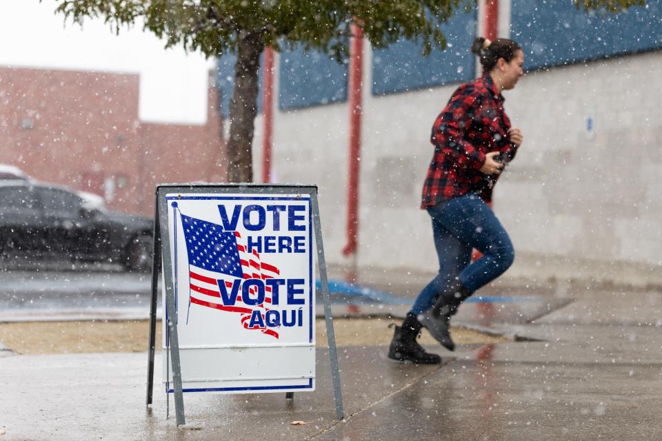 A voter runs through the snow to cast a ballot inside Reno High School on November 8, 2022 in Reno, Nevada.