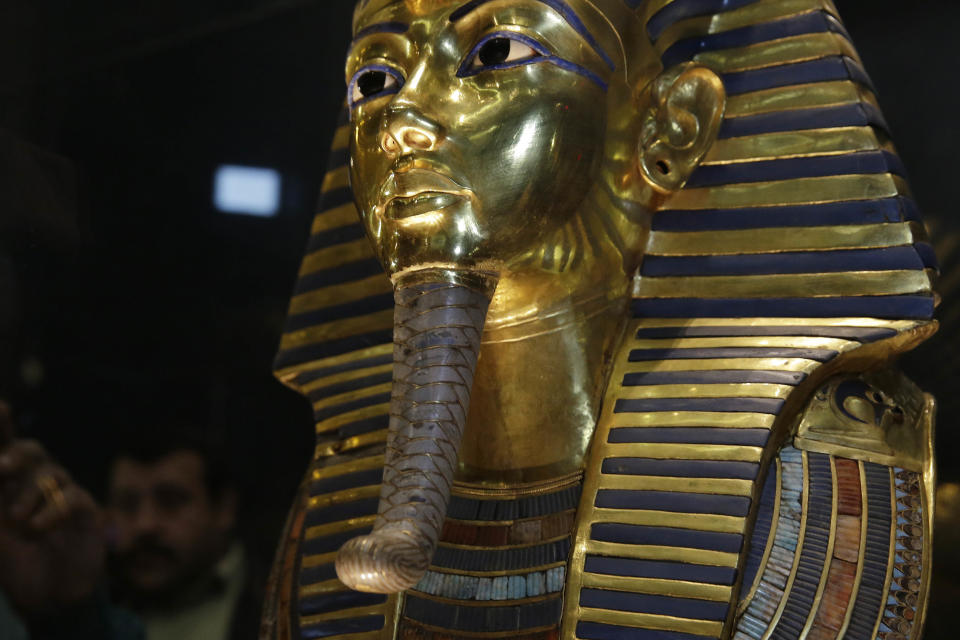 The gold mask of King Tutankhamun is seen in its glass case during a press tour, in the Egyptian Museum near Tahrir Square, Cairo, Egypt, Saturday, Jan. 24, 2015. German restoration specialist, Christian Eckmann, summoned to Cairo to examine the damaged burial mask, spoke at a packed news conference Saturday at the Egyptian museum, saying that epoxy used to glue the mask's beard back on can be removed and the mask properly restored. Eckmann said the beard, which has been detached before from the mask and had likely loosened over the years, was accidentally knocked off last August during work on the relic’s lighting. (AP Photo/Hassan Ammar)