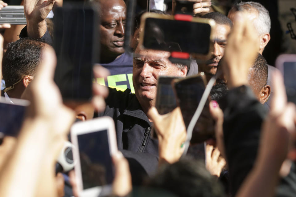 Brazil's former President Jair Bolsonaro greets supporters outside the Liberal Party's headquarters in Brasilia, Brazil, Thursday, March 30, 2023. Bolsonaro arrived back in Brazil on Thursday after a three-month stay in Florida. (AP Photo/Gustavo Moreno)