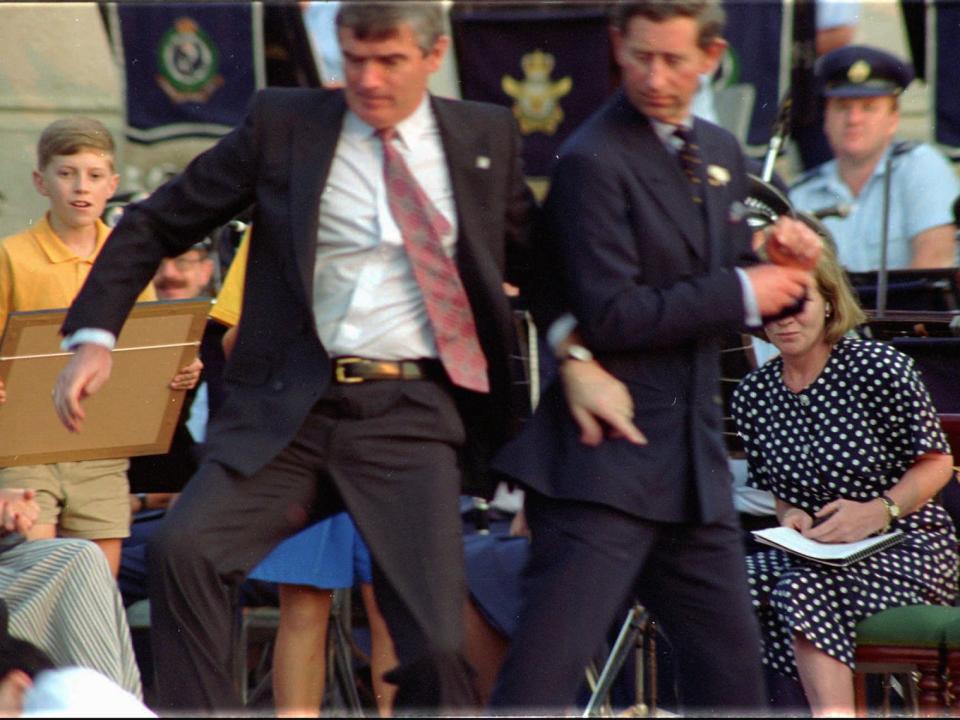 Britain's Prince Charles on right is pushed to safety by a security man in this file photo from January 26, 1994 when student David Kang, bottom left, had fired a starter's pistol at the Prince who was delivering an Australia Day speech in Sydney. The 24 year old Kang was found guilty of threatening violence in a Sydney court Thursday August 24, 1995 and will be sentenced Friday.