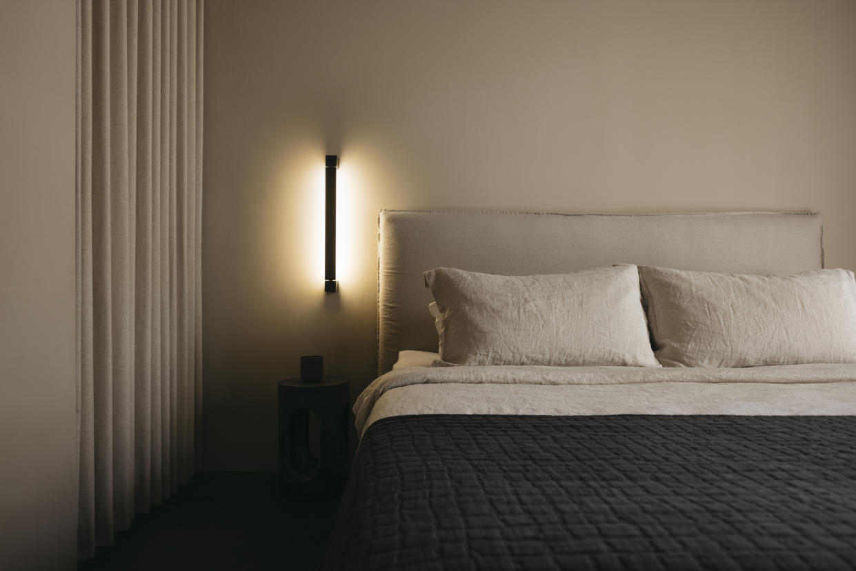  A bedroom with a recessed lighting and beige walls. 