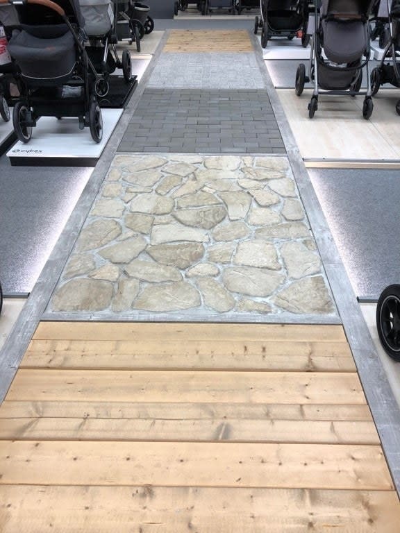 A baby store with wood, stone, and brick flooring areas next to strollers