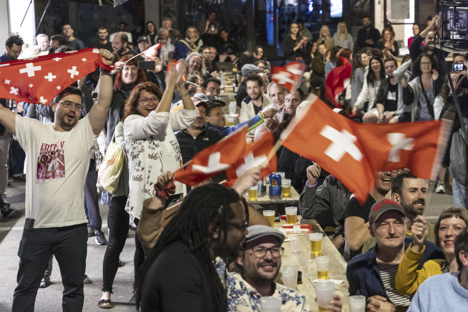 Supporters of singer Nemo, finalist of the 68th Eurovision Song Contest ESC, celebrate during a public viewing watching the broadcast of the ESC finals as Nemo is declared winner of the competition, in the early hours of Sunday, May 12, 2024, in Biel, Switzerland. Biel is Nemo's hometown. (Adrian Reusser/Keystone via AP)