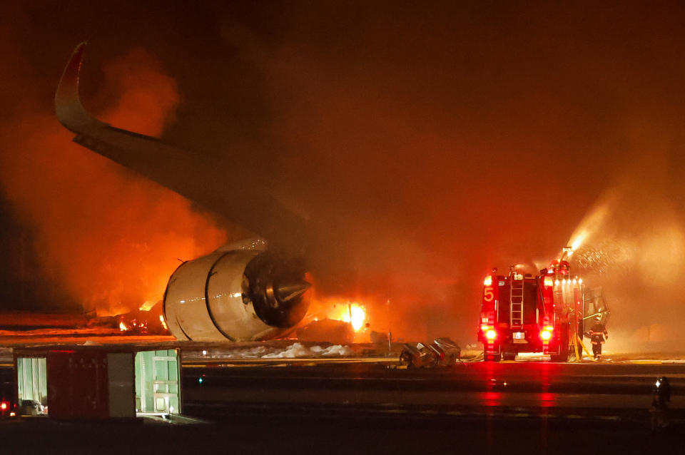 Firefighters work at Haneda International Airport after Japan Airlines' A350 airplane caught on fire, in Tokyo, Japan January 2, 2024. REUTERS/Issei Kato