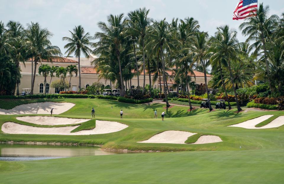 Golfers play on the green in May during the Rafe Cochran Golf Classic at Trump International Golf Club near West Palm Beach. Trump pays taxes only on the clubhouse under a longtime agreement with county authorities. He instead leases the land for the club's two golf courses.