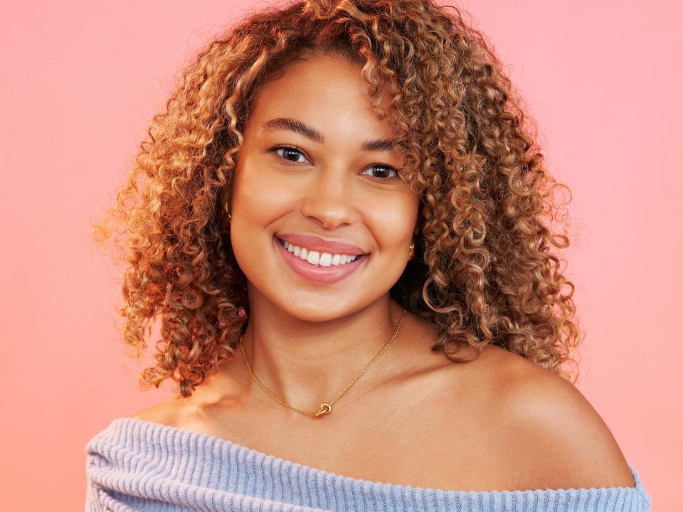 Erika poses for photos in a blue off-the-shoulder sweater and jeans.