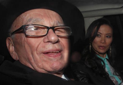 News Corp Chief Rupert Murdoch and his wife Wendi Deng drive away from the High Court in central London on April 25. Murdoch has admitted there was a "cover-up" over phone hacking at Britain's News of the World tabloid but tried to shift the blame away from himself and senior executives at his media empire