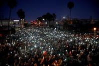 <p>People hold candles and flashlights into the air during a memorial for Rachael Parker and Sandy Casey, Manhattan Beach city employees and victims of the October 1st Las Vegas Route 91 music festival mass shooting, in Manhattan Beach, Calif., Oct. 4, 2017. (Photo: Patrick T. Fallon/Reuters) </p>