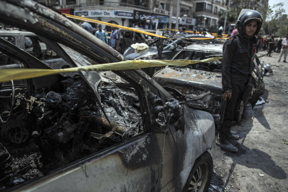 FILE - In this June 29, 2015 file photo, a policeman stands guard at the site of a car bombing that killed Egypt's top prosecutor, Hisham Barakat, in Cairo. On Wednesday, Feb. 20, 2019 Egypt executed nine suspected Muslim Brotherhood members convicted of involvement in the 2015 assassination of Barakat, security officials said. The nine were found guilty of taking part in the bombing that killed Barakat, the first assassination of a senior official in Egypt in a quarter century. (AP Photo/Eman Helal, File)