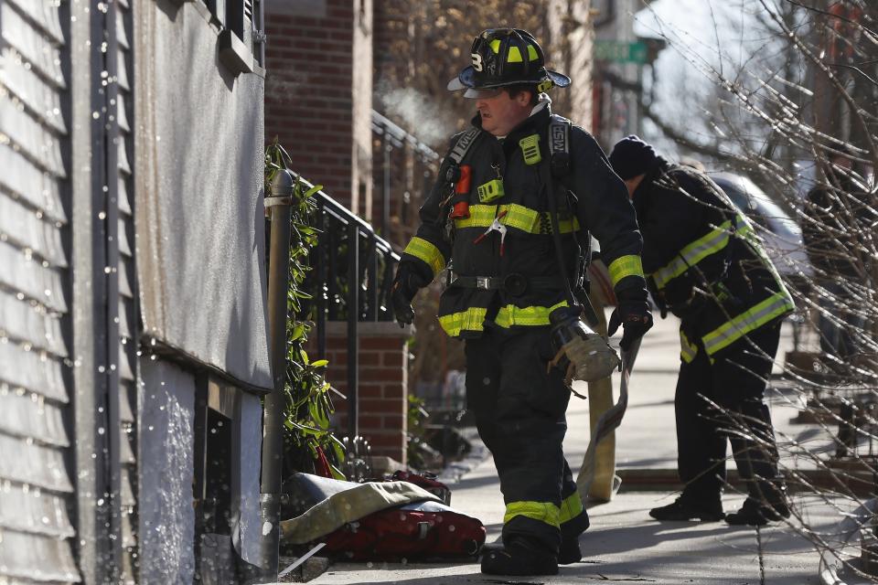 Firefighters work at the scene of a fire in a residential building, Friday, Feb. 3, 2023, in the East Boston neighborhood of Boston. An Arctic front sweeping in from Canada has led to frigid weather in the Northeast. (AP Photo/Michael Dwyer)