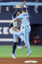 Toronto Blue Jays right fielder George Springer, left, celebrates with second baseman Whit Merrifield (15) after defeating the Washington Nationals in baseball game action in Toronto, Monday, Aug. 28, 2023. (Andrew Lahodynskyj/The Canadian Press via AP)