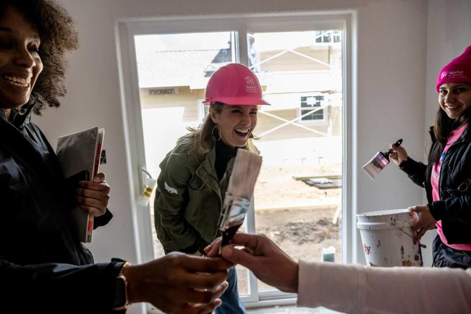 First Partner Jennifer Siebel Newsom, center, laughs as her paint brush is taken away while she was helping Monique Lujan, right, paint her home during an event with Habitat for Humanity in celebration of International Women’s Day in Sacramento in March.