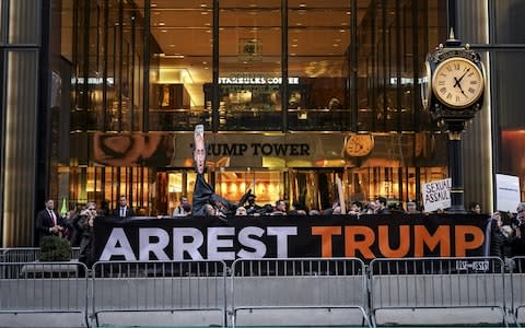 'Arrest Trump' banners could be seen outside the president's iconic New York building - Credit: Drew Angerer/Getty