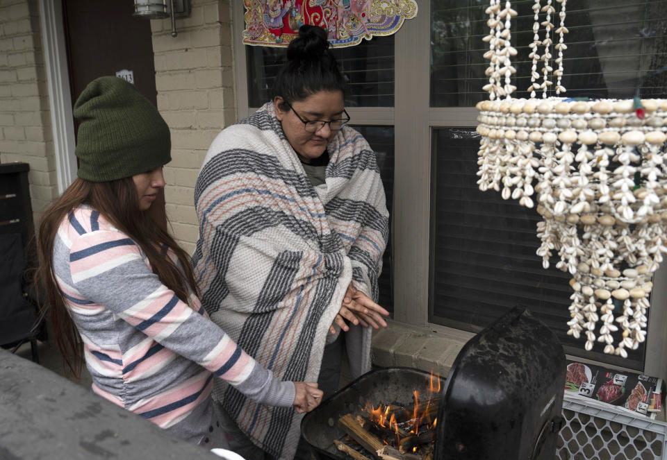 Image:  Karla Perez and Esperanza Gonzalez warm up by a barbecue grill during the power outage (Go Nakamura / Getty Images)