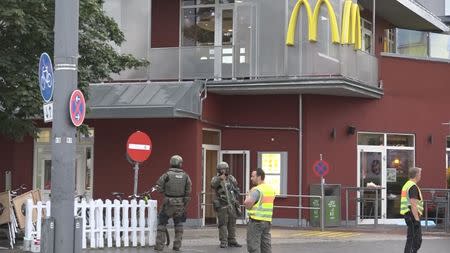 A screen grab taken from video footage shows special forces police officers standing guard next to a fast foot restaurant following a shooting rampage at the Olympia shopping mall in Munich, Germany July 22, 2016. REUTERS/Non-stop News/Handout via Reuters TV