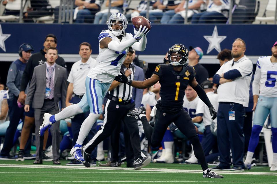 Dallas Cowboys cornerback Trevon Diggs (7) intercepts a pass intended for Washington Commanders wide receiver Jahan Dotson (1) in the first half of a NFL football game in Arlington, Texas, Sunday, Oct. 2, 2022. (AP Photo/Michael Ainsworth)