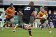 Australia's Tate McDermott, right, makes a run as teammate Australia's Michael Hooper, left, watches during the Rugby Championship game between the All Blacks and the Wallabies in Perth, Australia, Sunday, Sept. 5, 2021. (AP Photo/Gary Day)