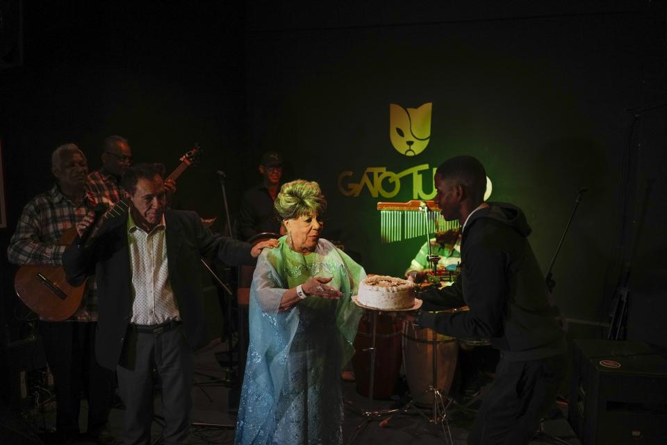 La cantante de bolero Migdalia Hechavarría recibe un pastel de cumpleaños durante su actuación en el club "El Gato Tuerto" en su 83 cumpleaños en La Habana, Cuba, el domingo 21 de enero de 2024. (AP Foto/Ramón Espinosa)