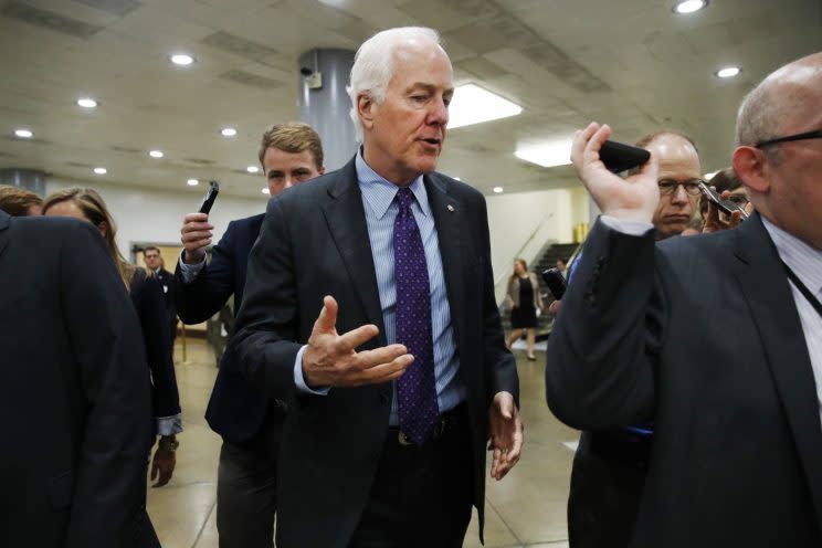 Senate Majority Whip John Cornyn of Texas, center, is pursued by reporters on Capitol Hill in Washington on July 11, 2017. (Photo: Jacquelyn Martin/AP)