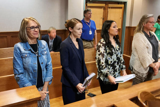 Sheena Greitens, center, the ex-wife of former Missouri Gov. and U.S. Senate candidate Eric Greitens, rises at the beginning of a court session in a child custody case on Thursday, June 23, 2022, at the Boone County Courthouse in Columbia, Mo. An attorney for Sheena Greitens said her client had received threats after a Senate campaign ad for Eric Greitens depicted him with a gun hunting "RINOs," or Republicans in Name Only. (AP Photo/David A. Lieb)