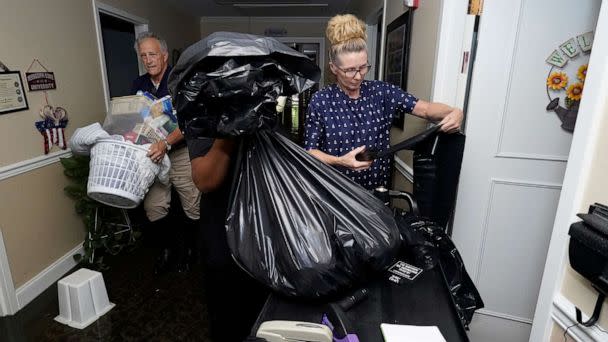 PHOTO: Residents, relatives and staff collect and carry out possessions from the flooded Peach Tree Village nursing home in Brandon, Miss., Aug. 24, 2022. (Rogelio V. Solis/AP)