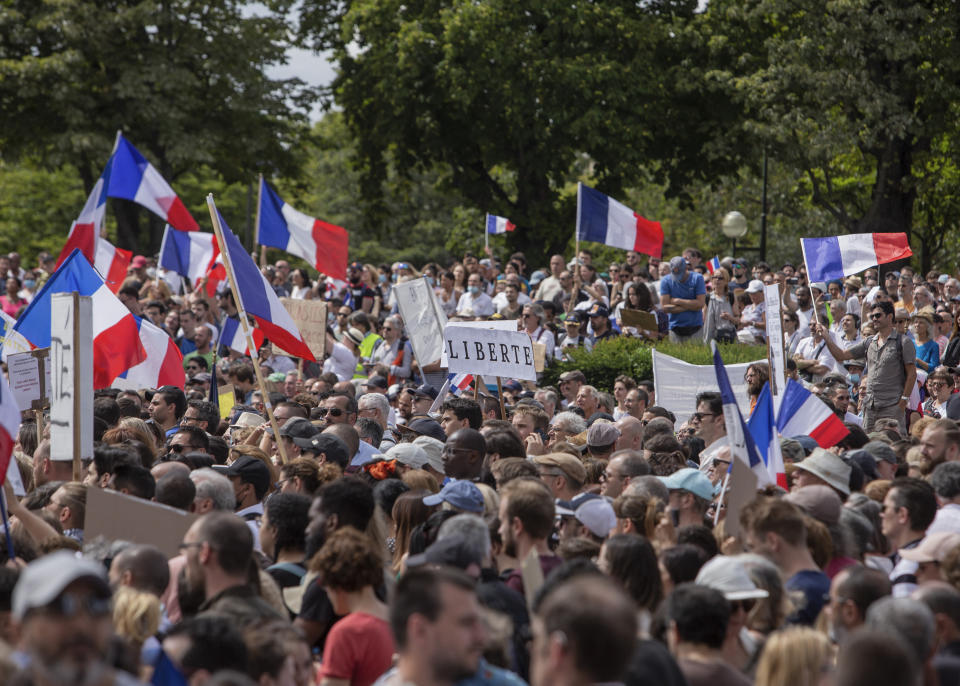 Thousands of protesters gather at Place Trocadero near the Eiffel Tower attend a demonstration in Paris, France, Saturday July 24, 2021, against the COVID-19 pass which grants vaccinated individuals greater ease of access to venues. (AP Photo/Rafael Yaghobzadeh)