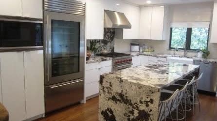 Tatyana Ali's kitchen with a granite island and top of the line appliances