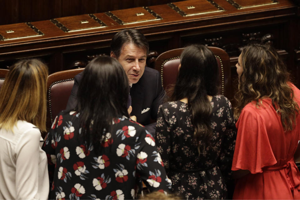 Italian Premier Giuseppe Conte, bottom center, talks with lawmakers during a confidence vote at the Lower Chamber in Rome, Monday, Sept. 9, 2019. Conte is pitching for support in Parliament for his new left-leaning coalition ahead of crucial confidence votes. (AP Photo/Gregorio Borgia)