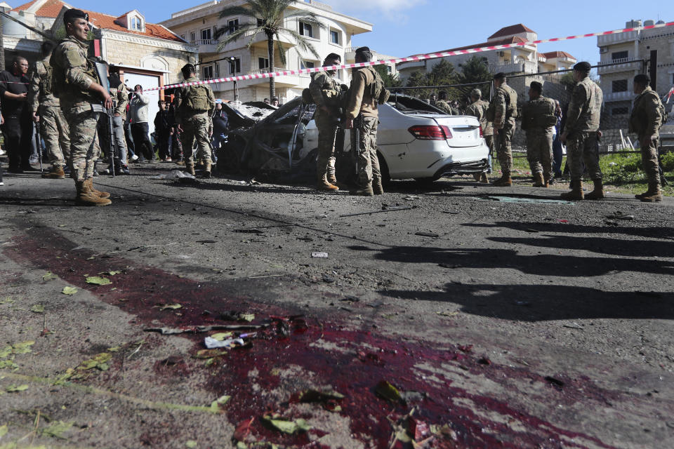 Lebanese army soldiers gather around a damaged car near the coastal town of Jadra, south Lebanon, Saturday, Feb. 10, 2024. An apparent Israeli drone strike hit a car near Lebanon's southern port city of Sidon Saturday killing at least two people and wounded others, security officials said. (AP Photo/Mohammed Zaatari)