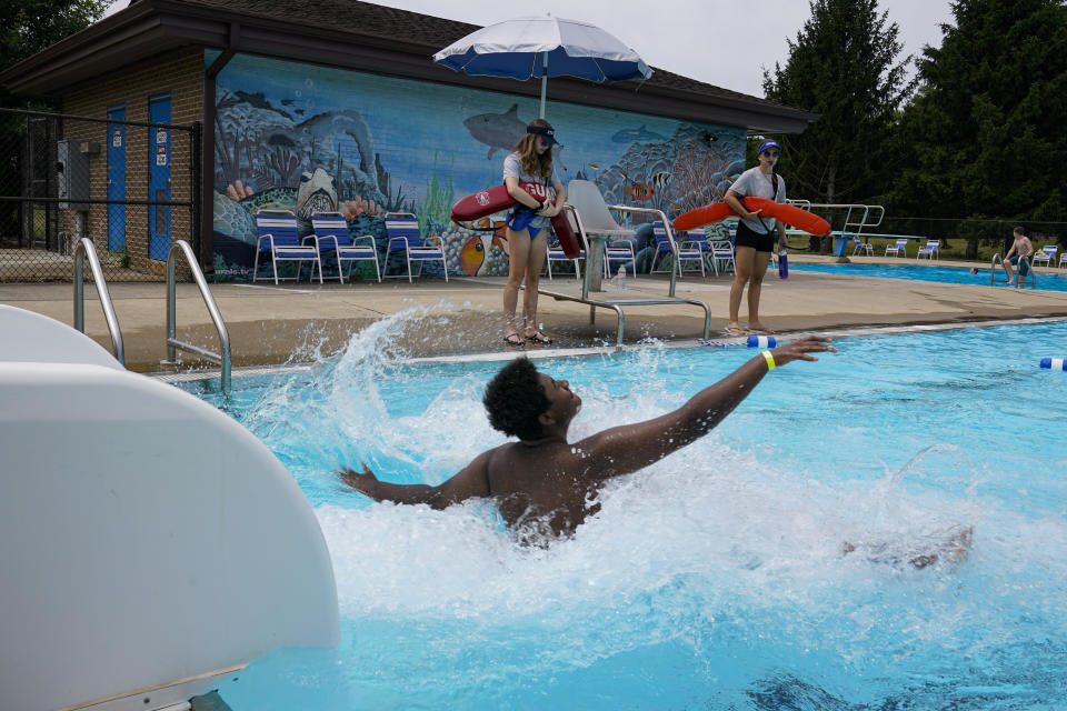 Lifeguards Hailey Landrun, 17, and Rachel Mees, 21, watch over swimmers at the Douglass Park pool in Indianapolis, Friday, June 17, 2022. Indianapolis typically fills 17 pools each year, but with a national lifeguard shortage exacerbated by the COVID-19 pandemic, just five are open this summer. The American Lifeguard Association estimates one-third of pools in the United States are impacted by the shortage. (AP Photo/Michael Conroy)