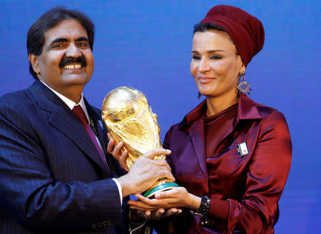 FILE PHOTO: Qatar's Emir Sheikh Hamad bin Khalifa al Thani and his wife Sheikha Moza Bint Nasser al-Misnad hold a copy of the World Cup trophy he received from FIFA President Sepp Blatter (unseen) after the announcement that Qatar will be the host nation for the FIFA World Cup 2022, in Zurich in this December 2, 2010. REUTERS/Arnd Wiegmann/File photo