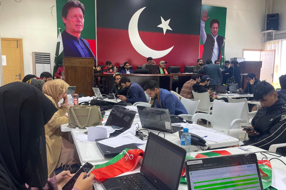 Huge banners of Imran Khan cover walls as workers continue to hold meetings at the central election monitoring cell at their Islamabad office (AFP via Getty Images)