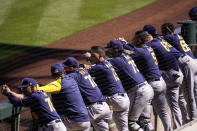 Milwaukee Brewers players watch from the dugout in the first inning of the team's spring baseball game against the Arizona Diamondbacks in Scottsdale, Ariz., Monday, March 1, 2021. (AP Photo/Jae C. Hong)