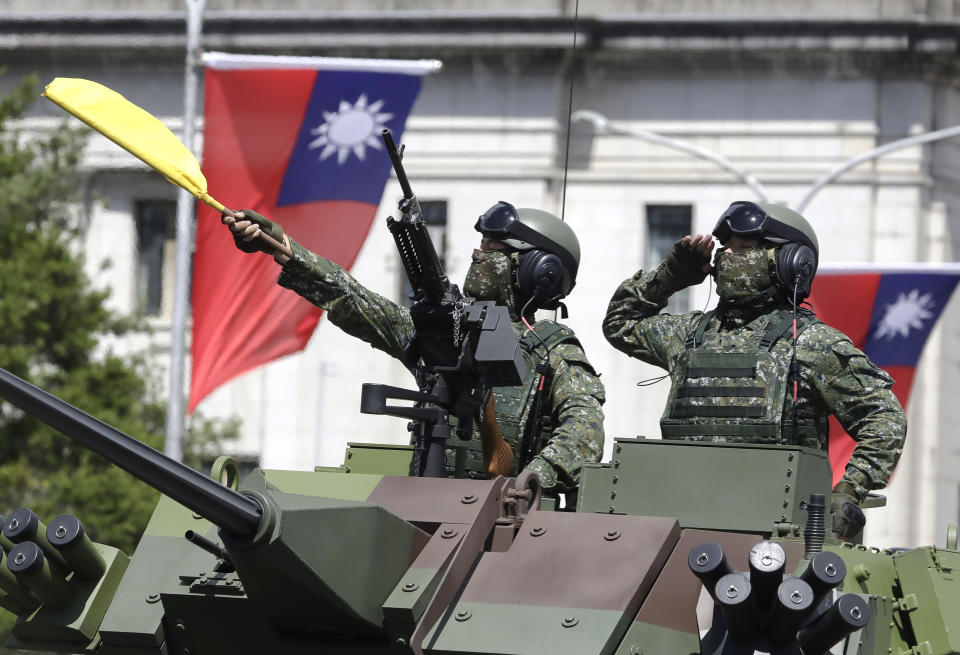 FILE - Taiwanese soldiers salute during National Day celebrations in front of the Presidential Building in Taipei, Taiwan on Oct. 10, 2021. Taiwan’s government is racing to counter China’s military, but many on the island say they don’t share the sense of threat. (AP Photo/Chiang Ying-ying, File)