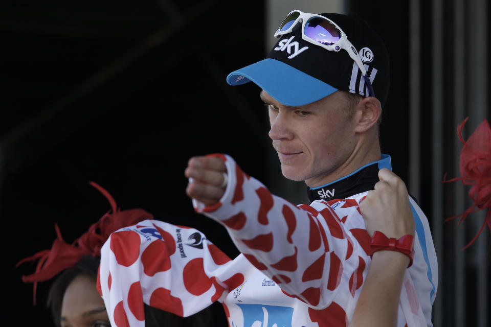 FILE - In this Saturday July 7, 2012 file photo, stage winner Christopher Froome of Britain adjusts the best climber's dotted jersey on the podium of the seventh stage of the Tour de France cycling race over 199 kilometers (123.6 miles) with start in Tomblaine and finish in La Planche des Belles Filles, France. Four-time Tour de France winner Chris Froome will miss this year’s race after a “bad crash” in training on Wednesday June 12, 2019. Team INEOS leader Dave Brailsford said Froome sustained a suspected fractured femur in a 60 kph (40 mph) crash. (AP Photo/Laurent Rebours, File)