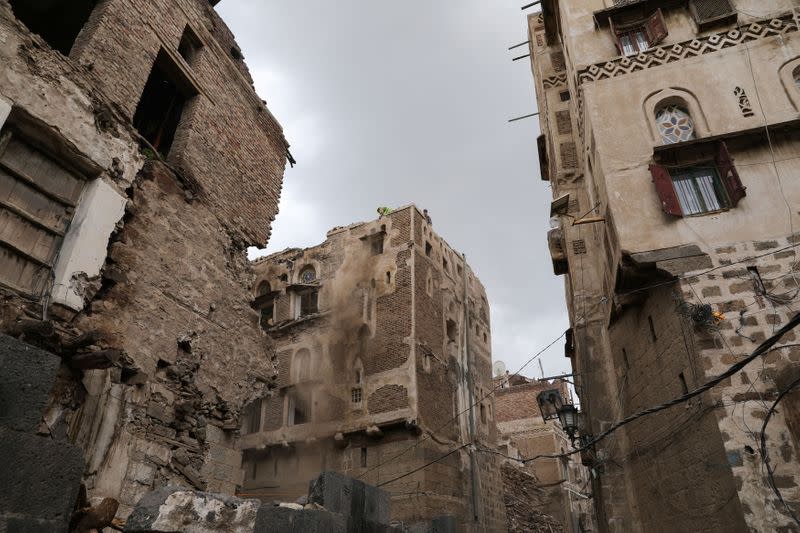 Workers demolish a building damaged by rain in the UNESCO World Heritage site of the old city of Sanaa