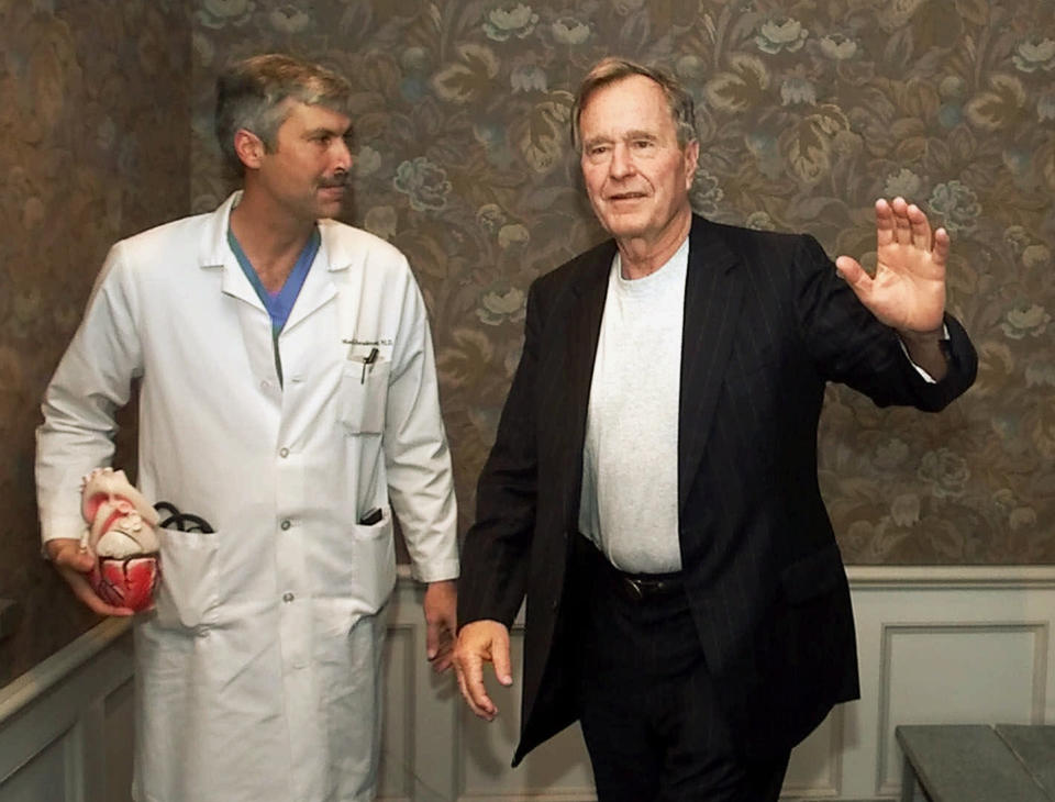 FILE - In this Feb. 25, 2000, file photo, former President George H.W. Bush waves as he leaves Methodist Hospital with his cardiologist, Mark Hausknecht, after a news conference in Houston. Hausknecht, who once treated former President George H.W. Bush, was fatally shot by a fellow bicyclist Friday, July 20, 2018, while riding through a Houston medical complex, and police were trying to determine if the shooting was random or a targeted act. (AP Photo/David J. Phillip, File)