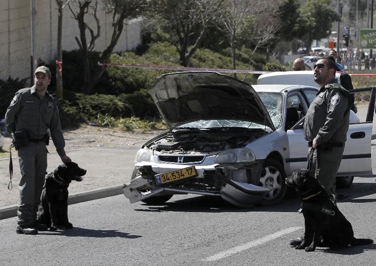 Israeli border guards stand near a car that ploughed into pedestrians in Jerusalem on March 6, 2015 injuring several people, before its driver got out and tried to stab them, in an attack mirroring similar incidents last year