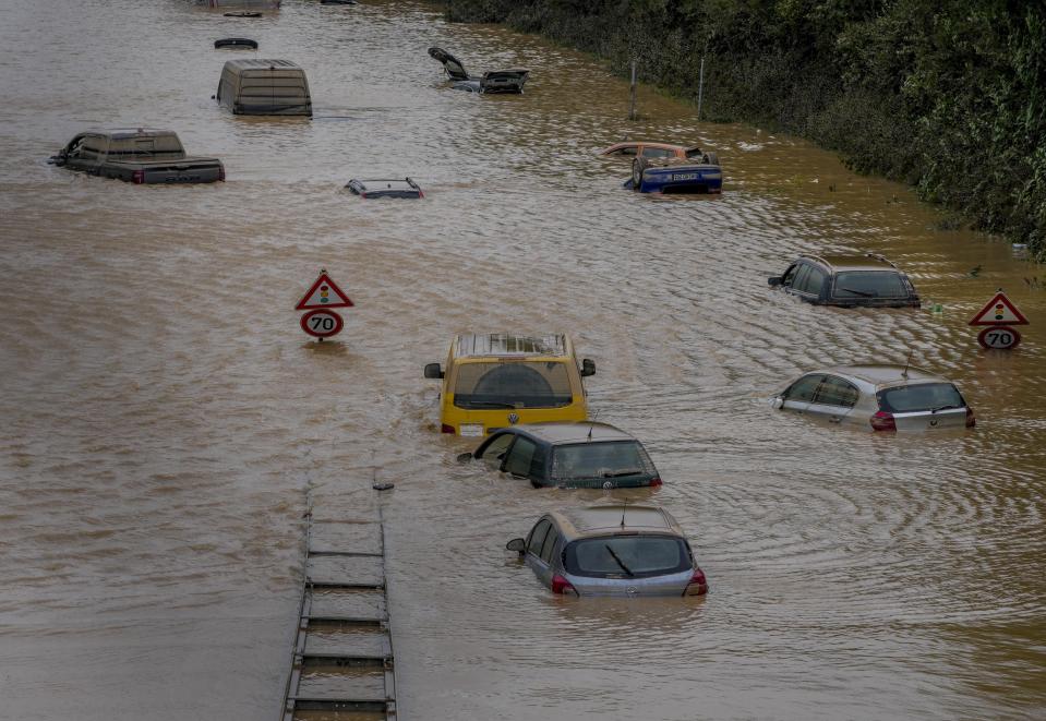 Cars show up as the flood sinks on a road in Erftstadt, Germany, Saturday, July 17, 2021. Due to strong rain falls the small Erft river went over the banks causing massive damages. (AP Photo/Michael Probst)