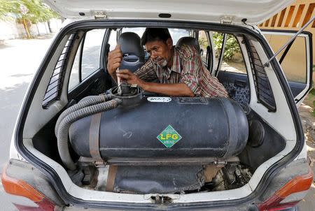 A mechanic repairs a pipe of a Liquefied Petroleum Gas (LPG) tank installed in a car outside his workshop in Ahmedabad, India October 6, 2015. REUTERS/Amit Dave