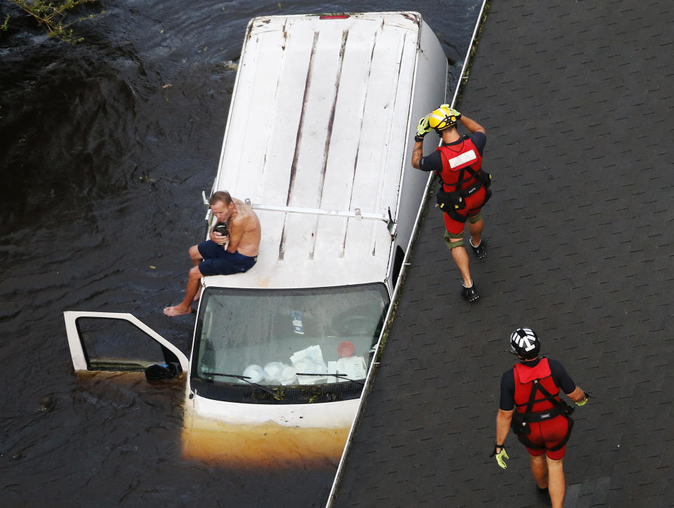 Los rescatistas trabajan intensamente para poner a salvo a las personas atrapadas en medio de las inundaciones. (AP Photo/Steve Helber)