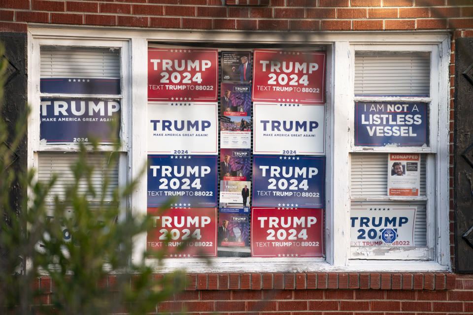 Windows filled with Trump 2024 campaign posters, a sign reading "I am not a listless vessel," and a smaller Trump 2020 poster