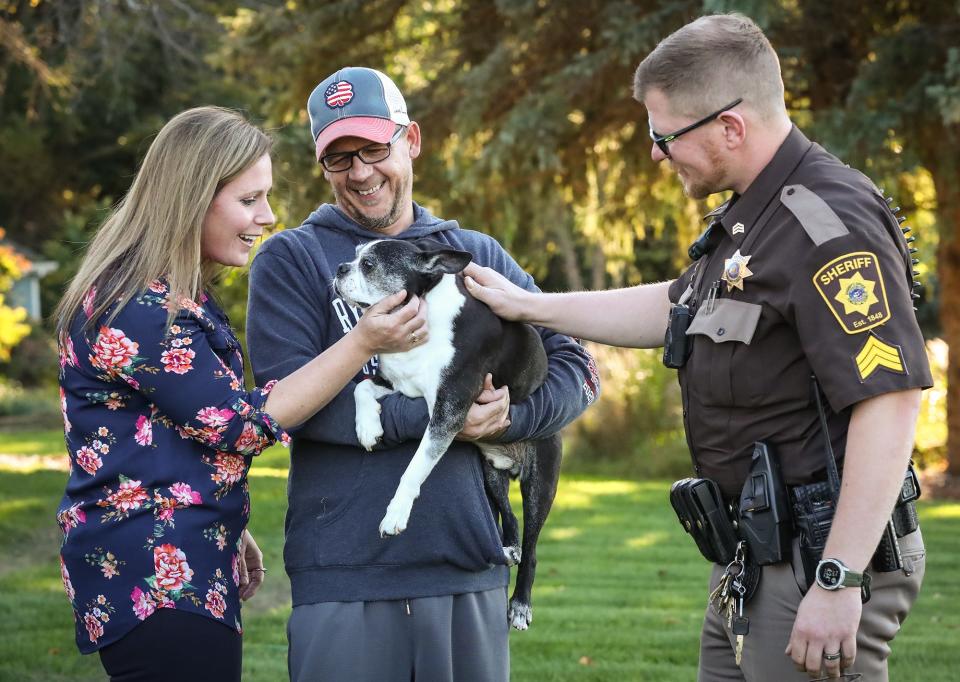 Brooke Boyle-Schneider and her husband Bob Schneider pet their 14-year-old dog Buddy with Fond du Lac County Sheriff's Sgt. Paul Metzger at their rural home in the Town of Taycheedah. Metzger found the dog, who is mostly blind and deaf, wandering on a nearby street after he lost his way from home in the early morning hours of Oct. 7.