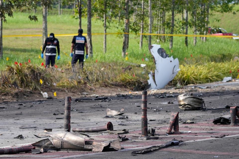 Members of the fire and rescue department inspect the crash site of a small plane in Shah Alam district (AP)