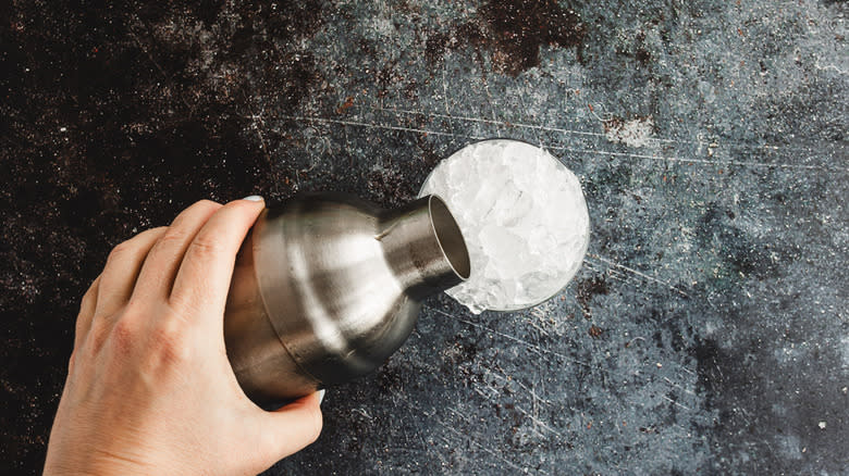 Pouring cocktail from shaker on ice