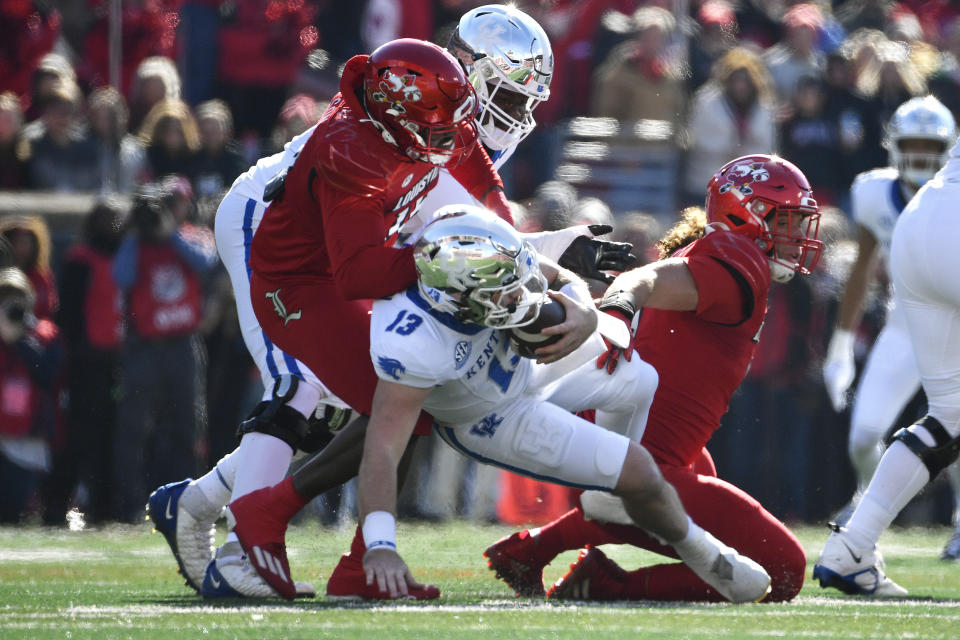 Kentucky quarterback Devin Leary (13) is sacked by Louisville defensive lineman Kameron Wilson (15), during the first half of an NCAA college football game in Louisville, Ky., Saturday, Nov. 25, 2023. (AP Photo/Timothy D. Easley)