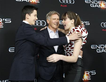 Cast members Asa Butterfield (L), Hailee Steinfeld (R) and Harrison Ford greet each other at the premiere of "Ender's Game" at the TCL Chinese theatre in Hollywood, California October 28, 2013. REUTERS/Mario Anzuoni