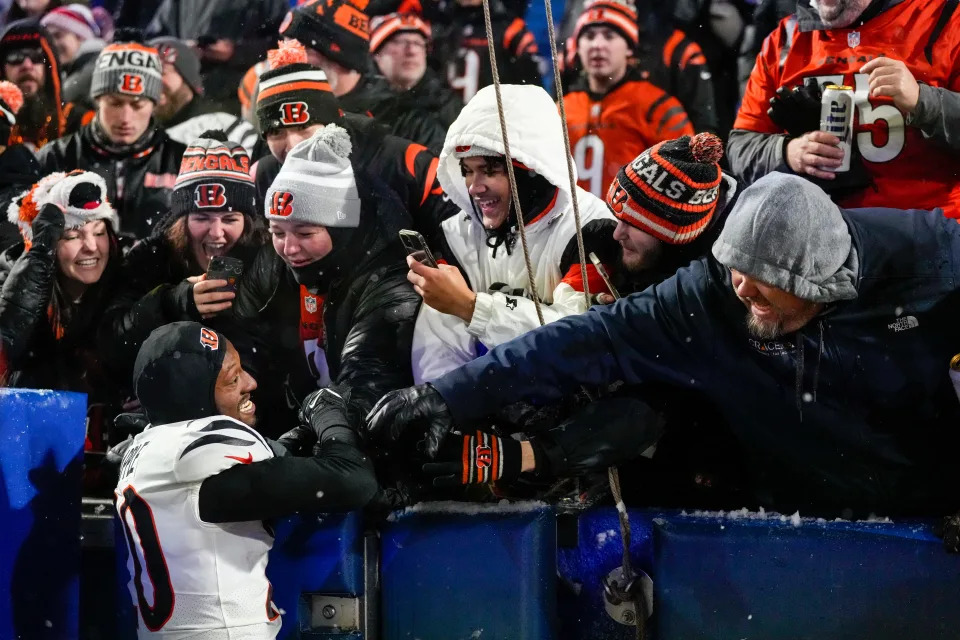 Bengals fans celebrate a playoff win in Buffalo with cornerback Eli Apple