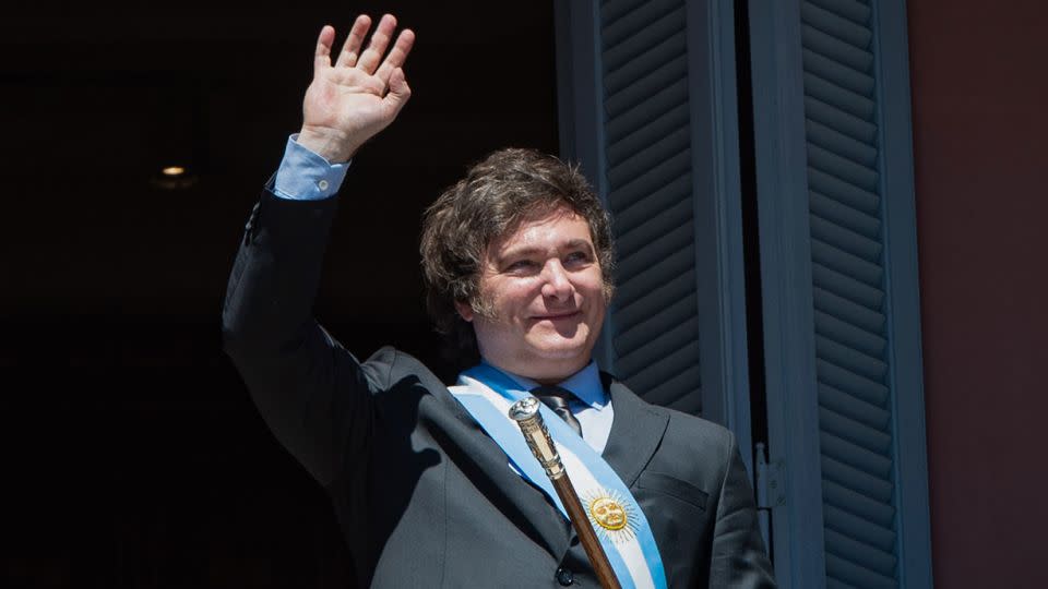 Javier Milei waves to his supporters from the government palace after taking office as Argentina's president on December 10, 2023. - Florencia Martinpicture alliance/dpa/Getty Images/File