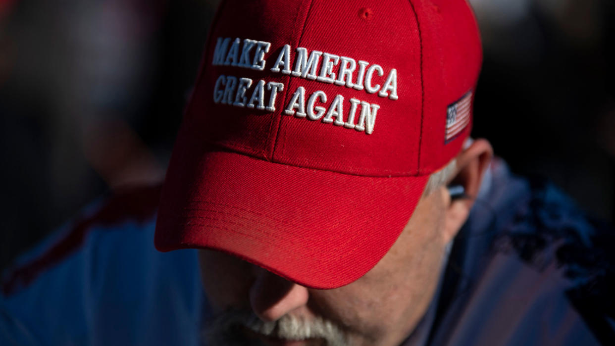 An attendee in a MAGA hat at a Trump rally.